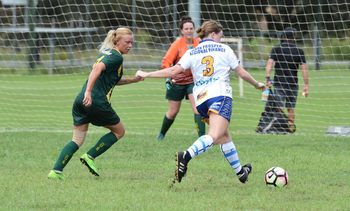 A Macleay Valley Rangers player prepares to fire a shot at goal while a Upper Macleay Yowies defend attempts to apply pressure.