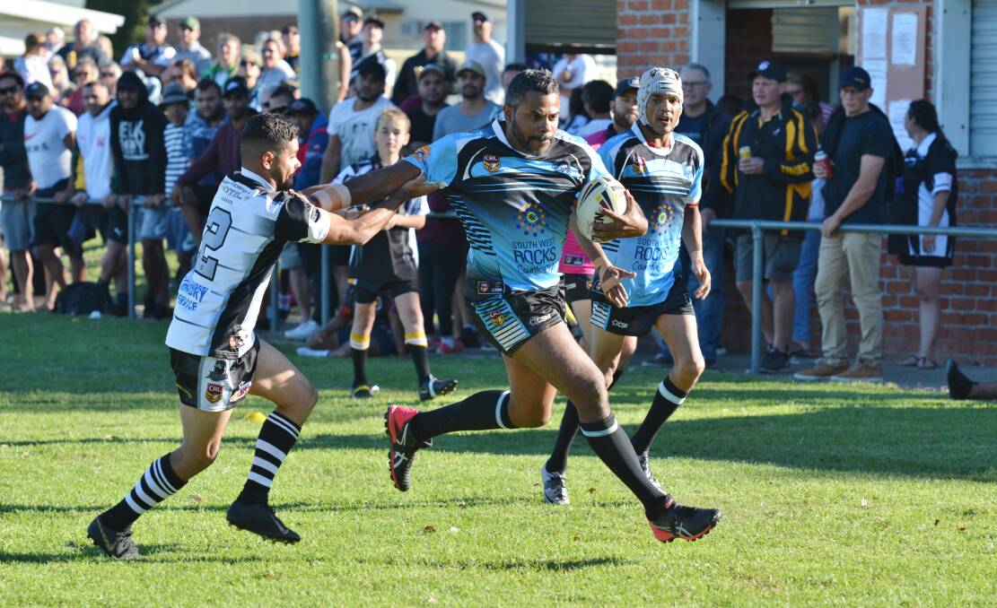 Stiff arm: A South West Rocks Marlins player fends off a would-be Lower Macleay Magpies defender. Photo: Penny Tamblyn