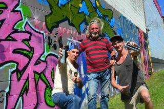 Graffiti artists Bill Moulton, Jim Moulton and Jacob Grant with the freshly painted mural near Services Club Park.